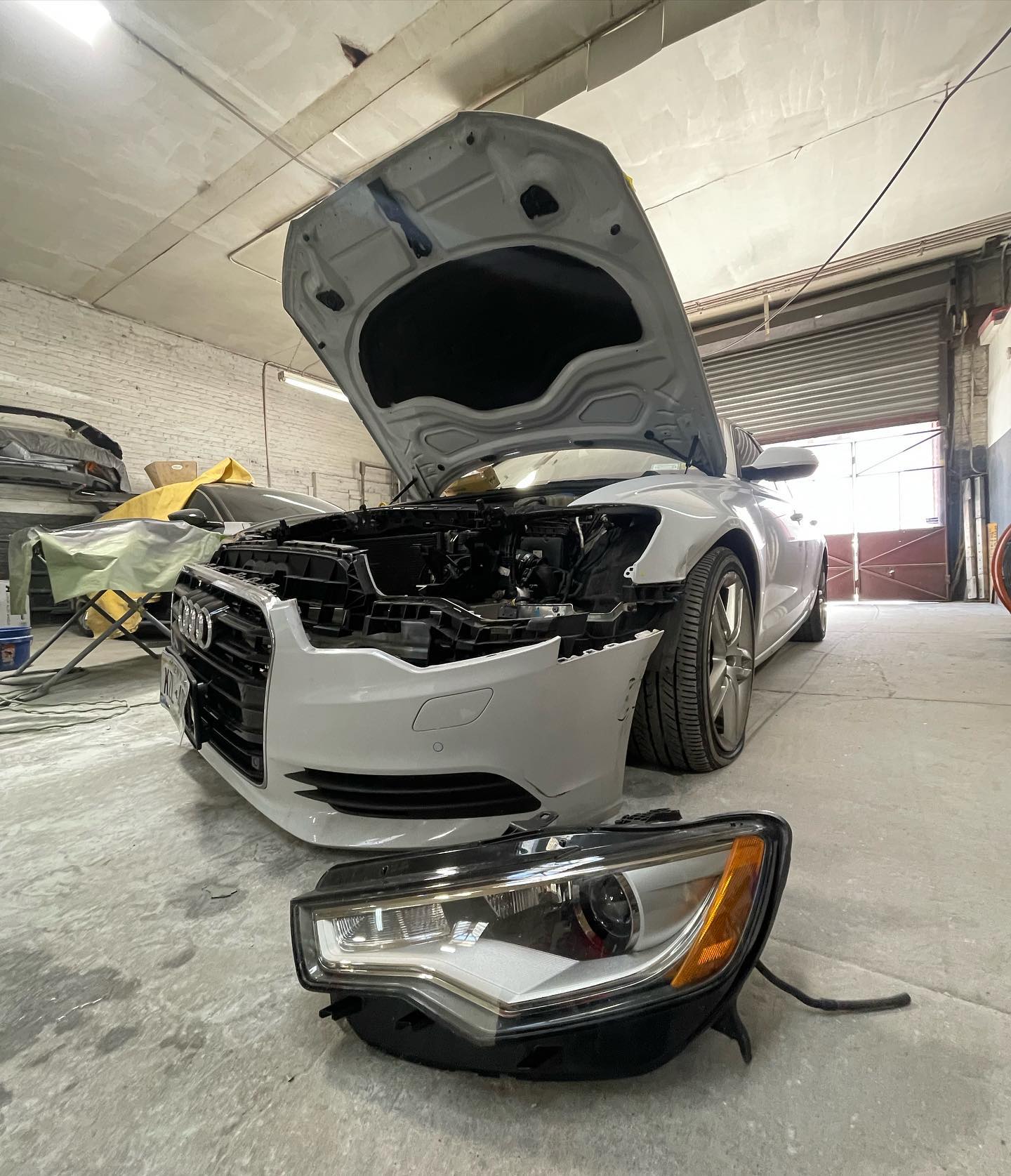 Audi A6 front headlight and bumper assembly during repair